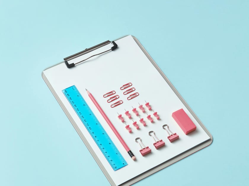 Office supplies and paper arranged on a clipboard