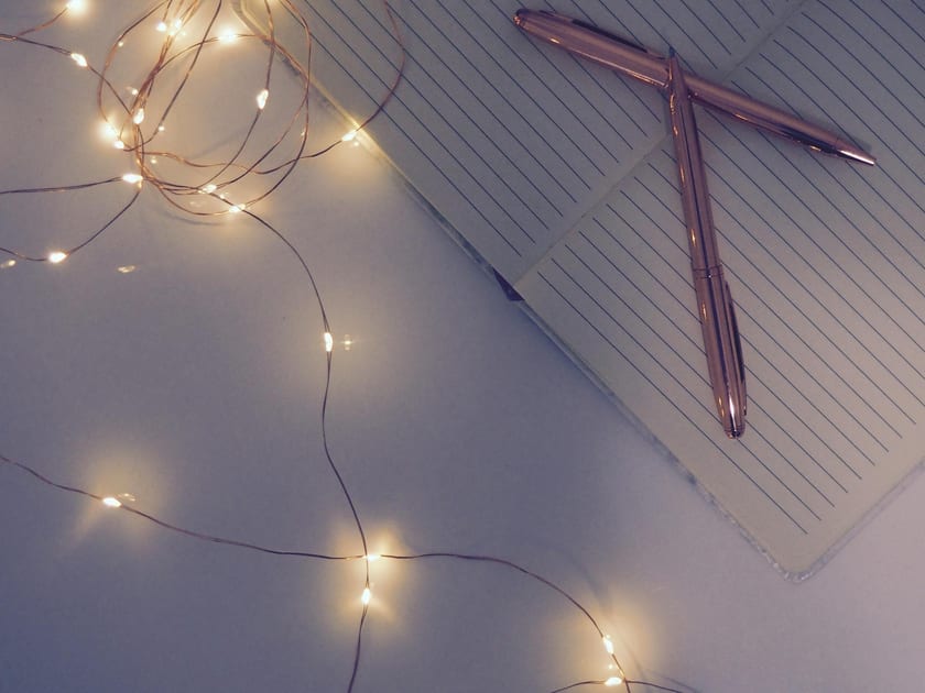 Notebook and pens on a softly lit desk