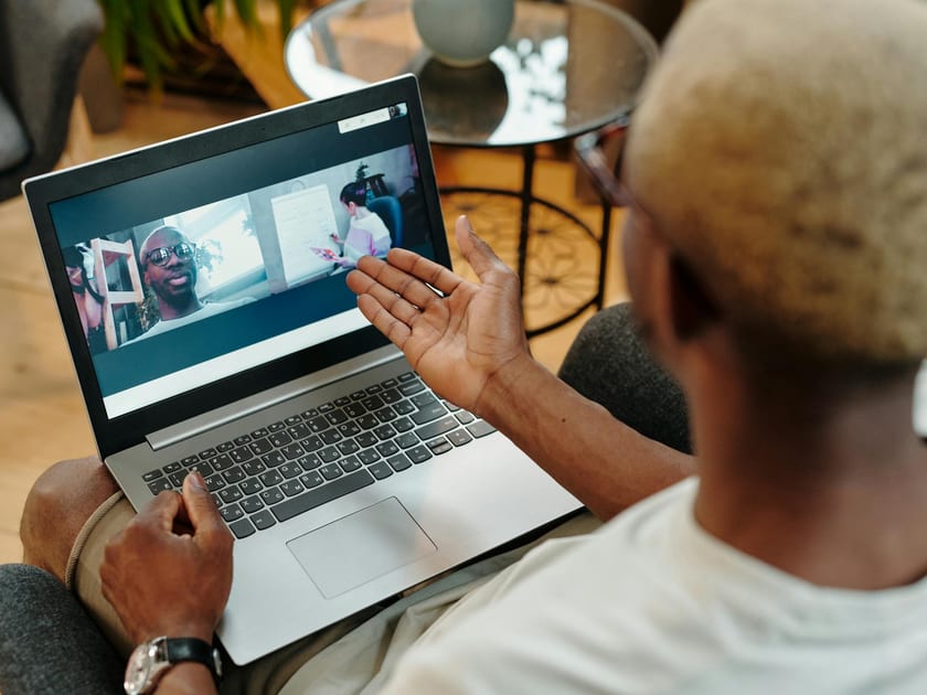 Person participating in a video call on a laptop at home